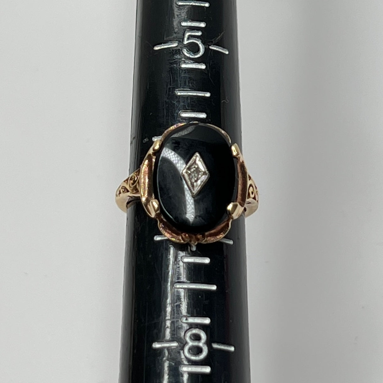Filigree band detail on gold onyx ring with vintage styling