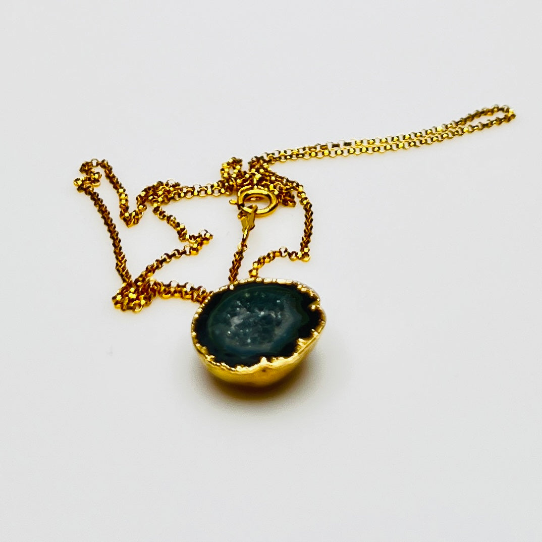 Close-up of geode slice pendant with gold bezel