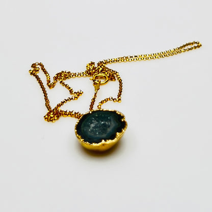 Close-up of geode slice pendant with gold bezel