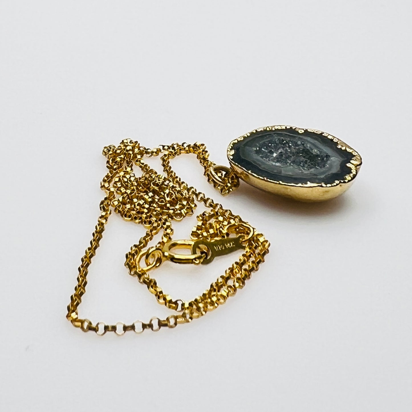 Close-up of geode slice pendant with gold bezel