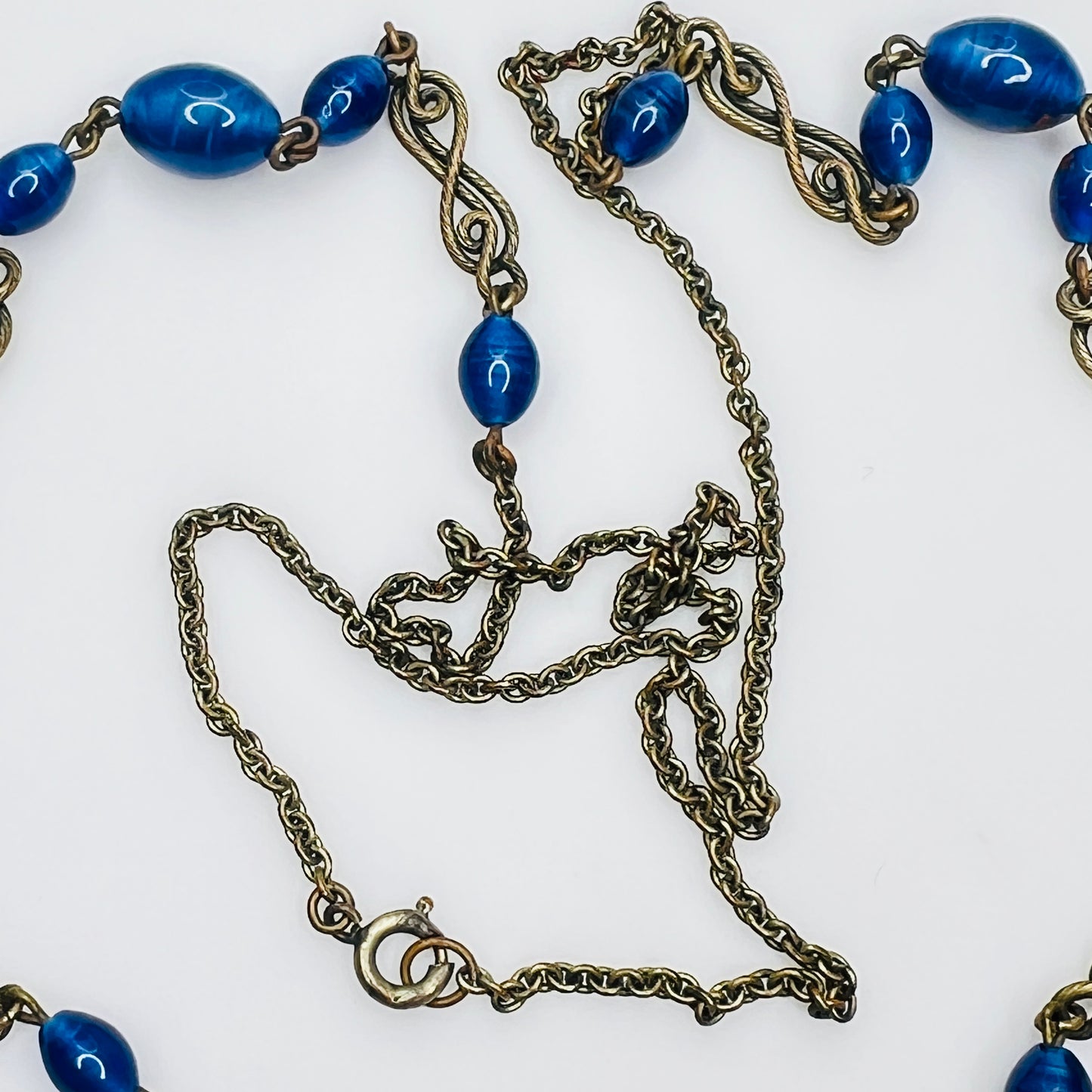 Ornate brass filigree fob pendant with blue glass