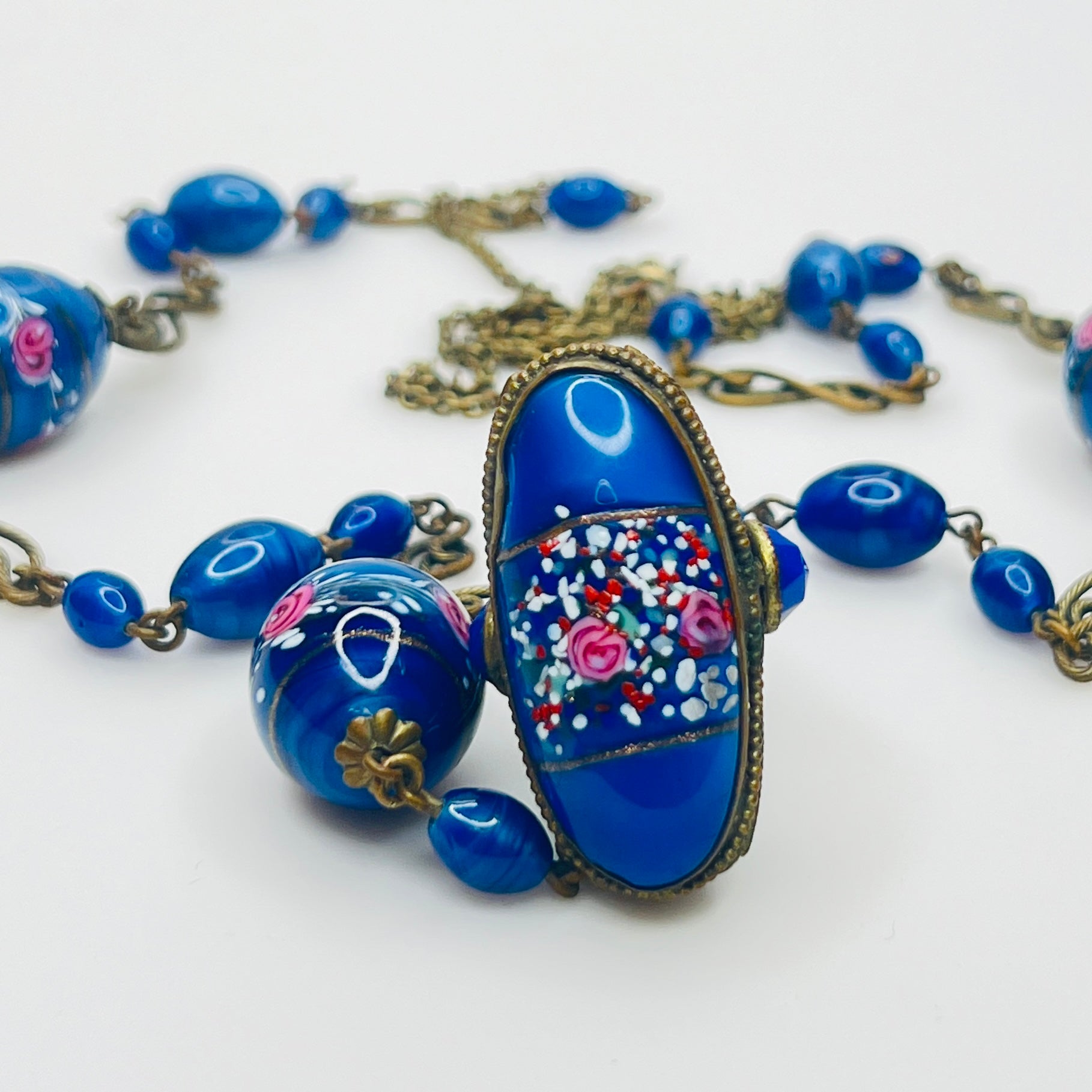 Ornate brass filigree fob pendant with blue glass