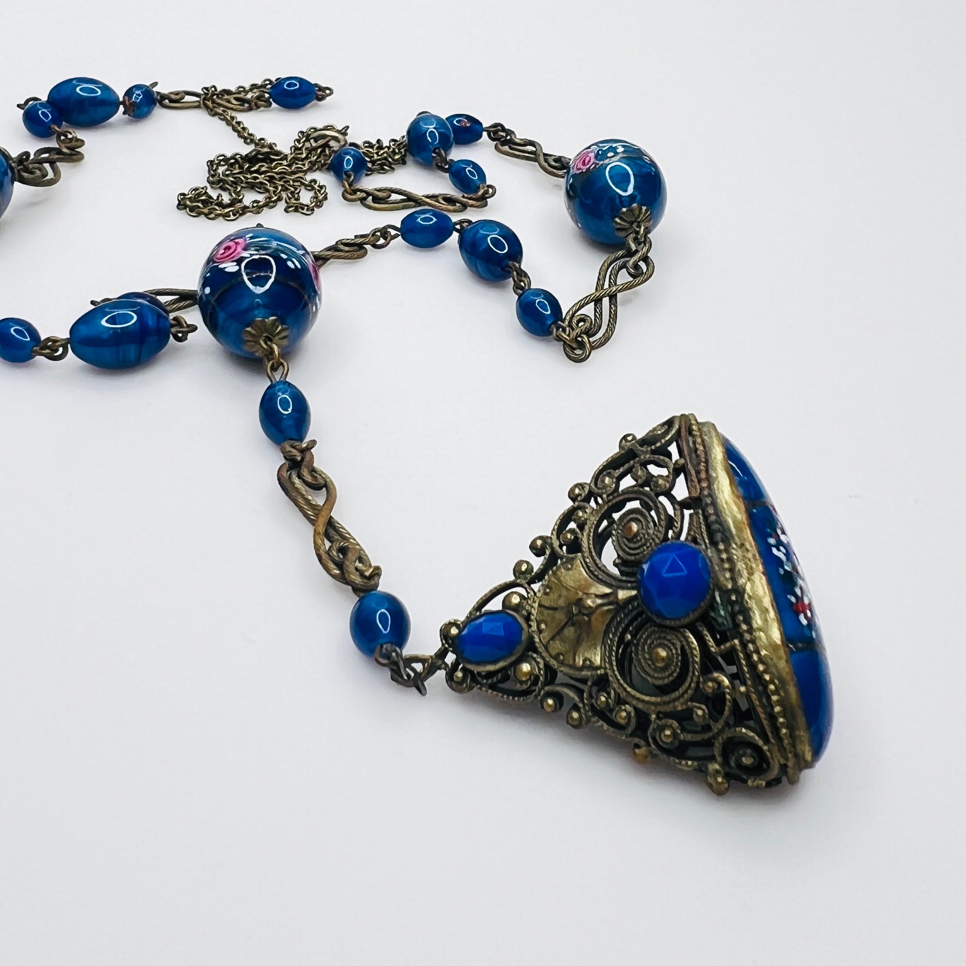 Ornate brass filigree fob pendant with blue glass