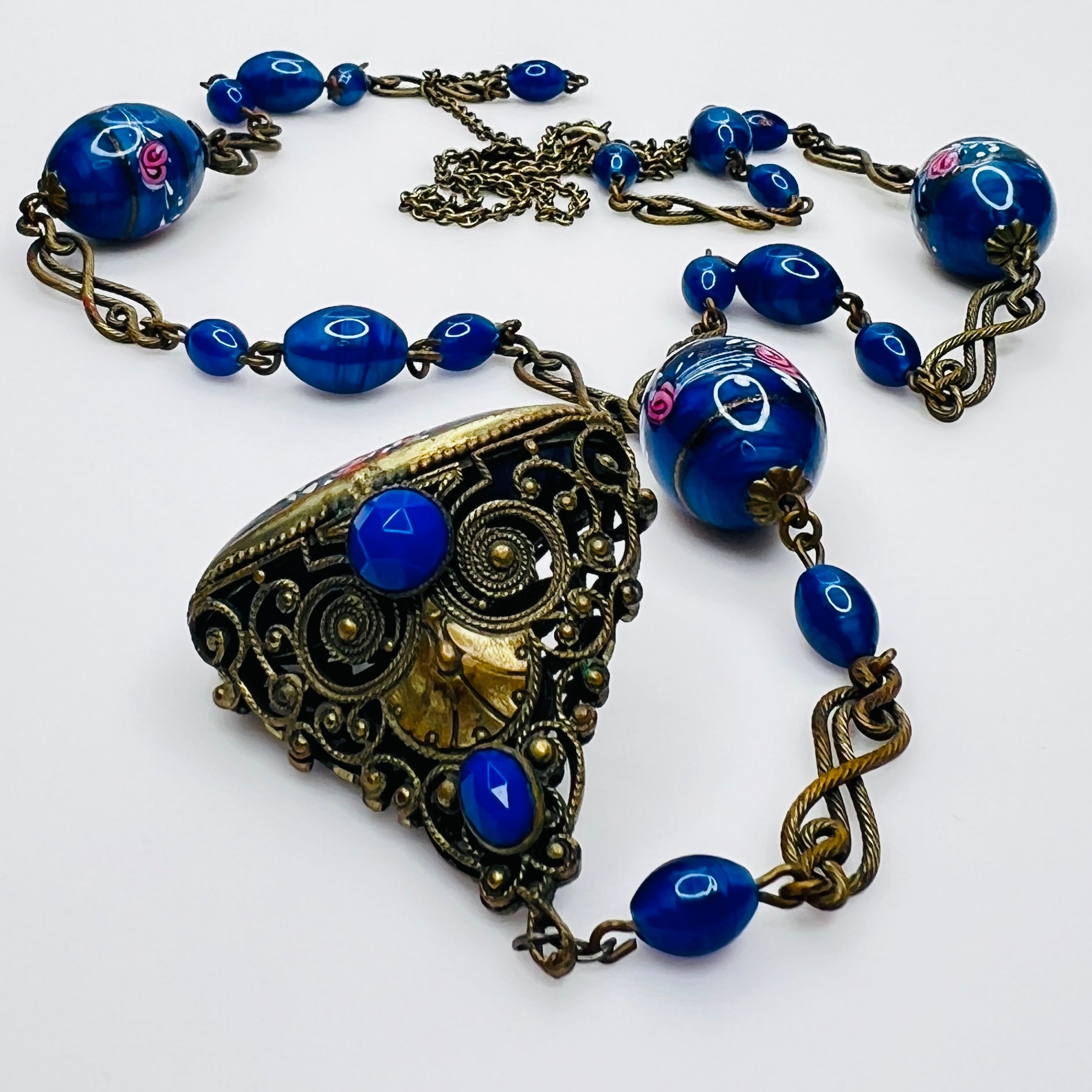 Ornate brass filigree fob pendant with blue glass