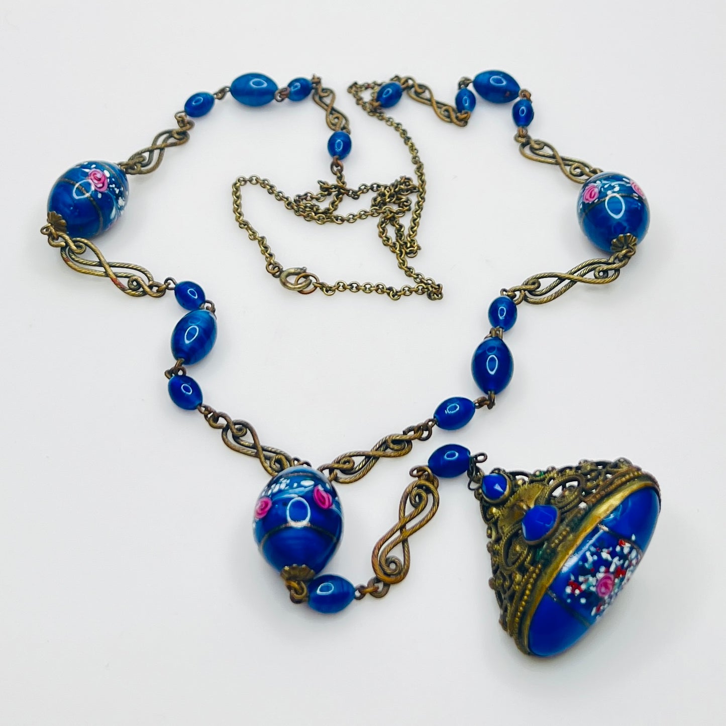 Ornate brass filigree fob pendant with blue glass