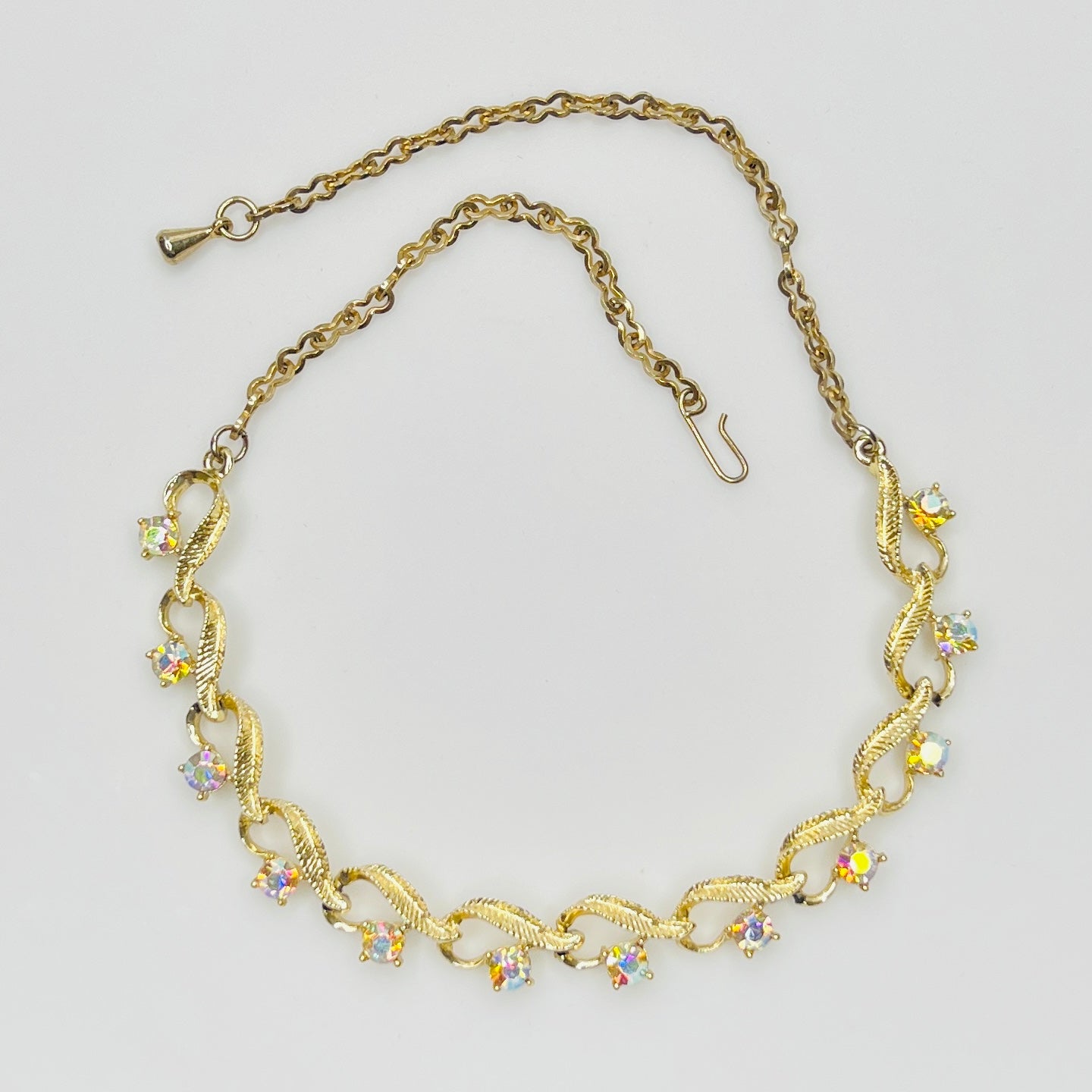 Flat lay of vintage aurora borealis choker with twisted gold links