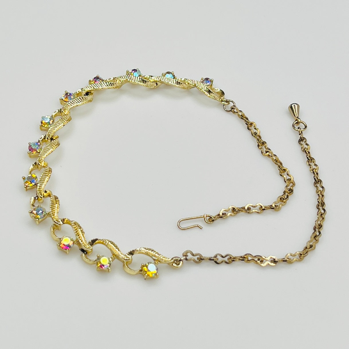 Flat lay of vintage aurora borealis choker with twisted gold links