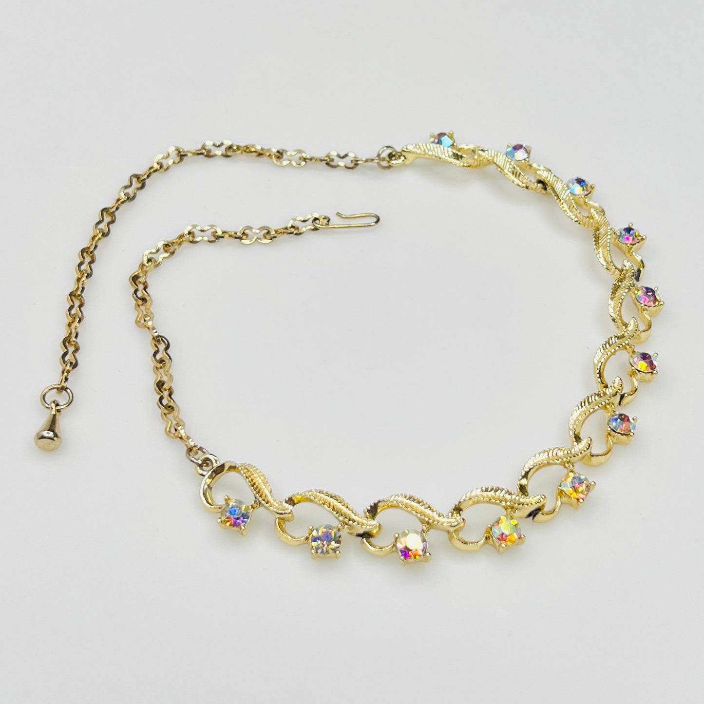 Flat lay of vintage aurora borealis choker with twisted gold links