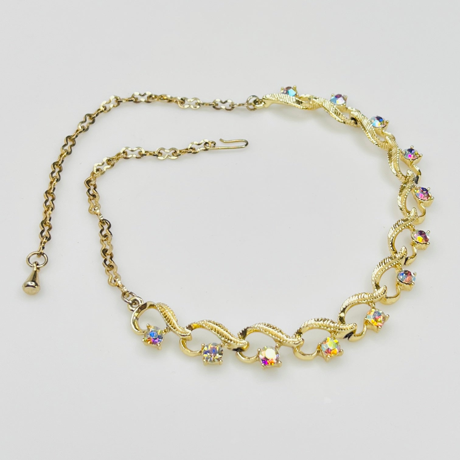 Flat lay of vintage aurora borealis choker with twisted gold links