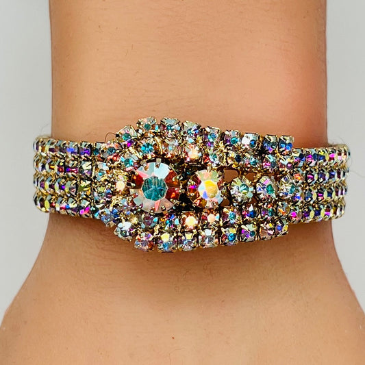 Vintage 1950s gold-tone clamper bracelet with Aurora Borealis rhinestones on wrist