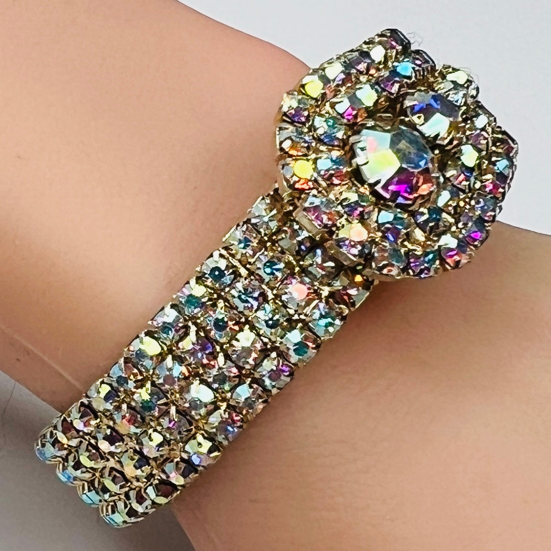 Vintage 1950s gold-tone clamper bracelet with Aurora Borealis rhinestones on wrist