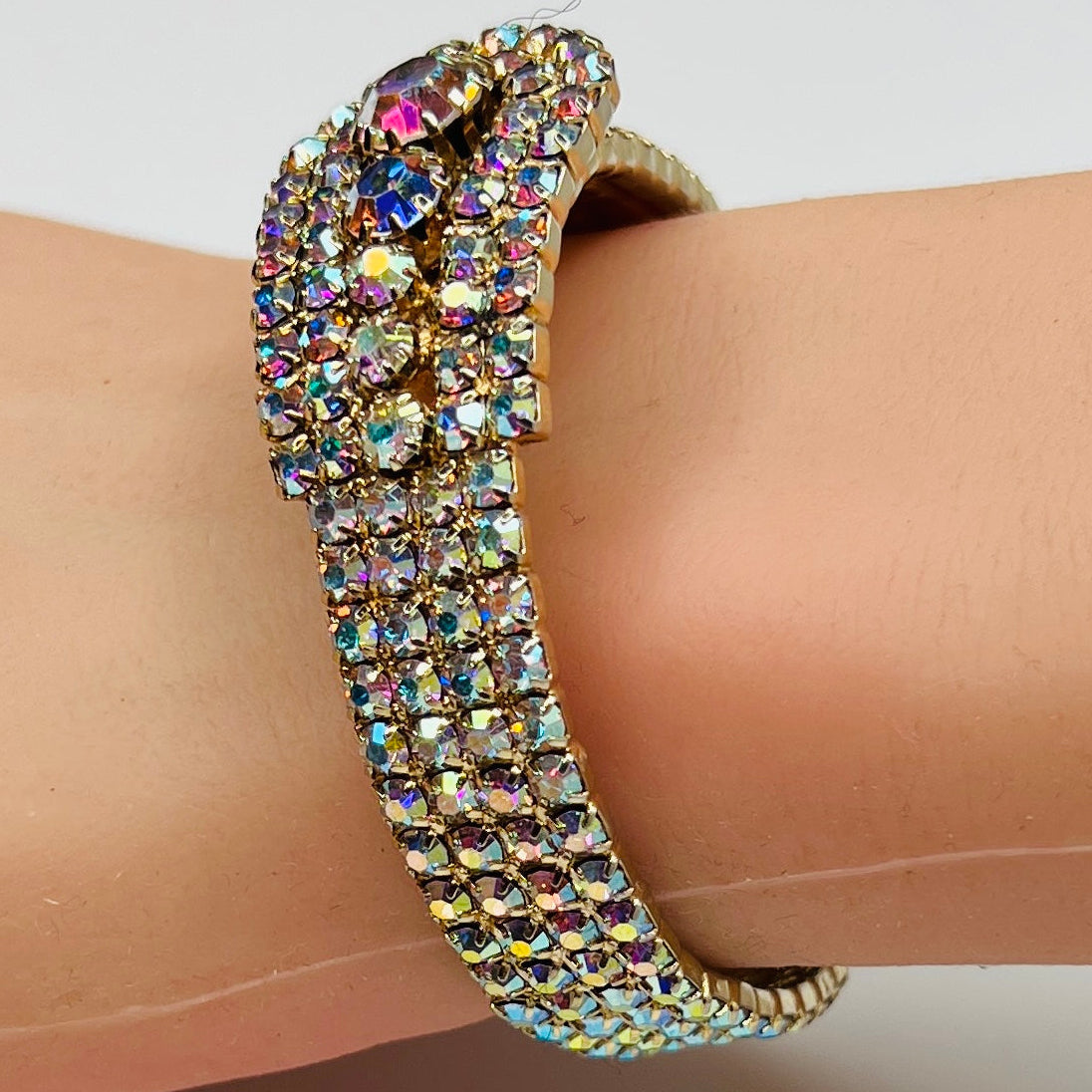 Vintage 1950s gold-tone clamper bracelet with Aurora Borealis rhinestones on wrist