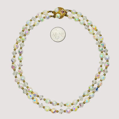 Flat lay of iridescent milk glass and crystal necklace with box clasp
