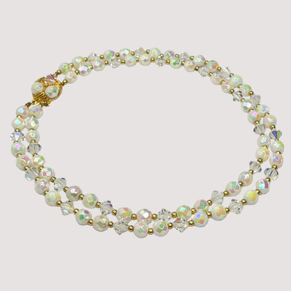 Flat lay of iridescent milk glass and crystal necklace with box clasp