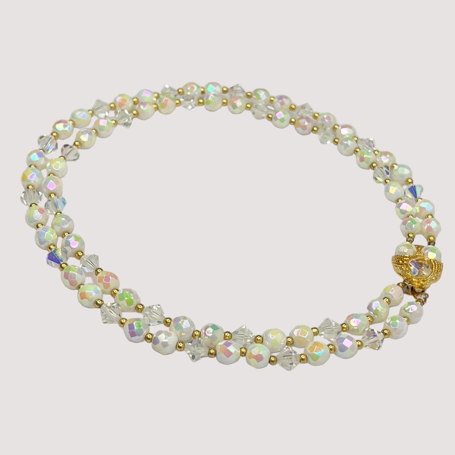 Flat lay of iridescent milk glass and crystal necklace with box clasp