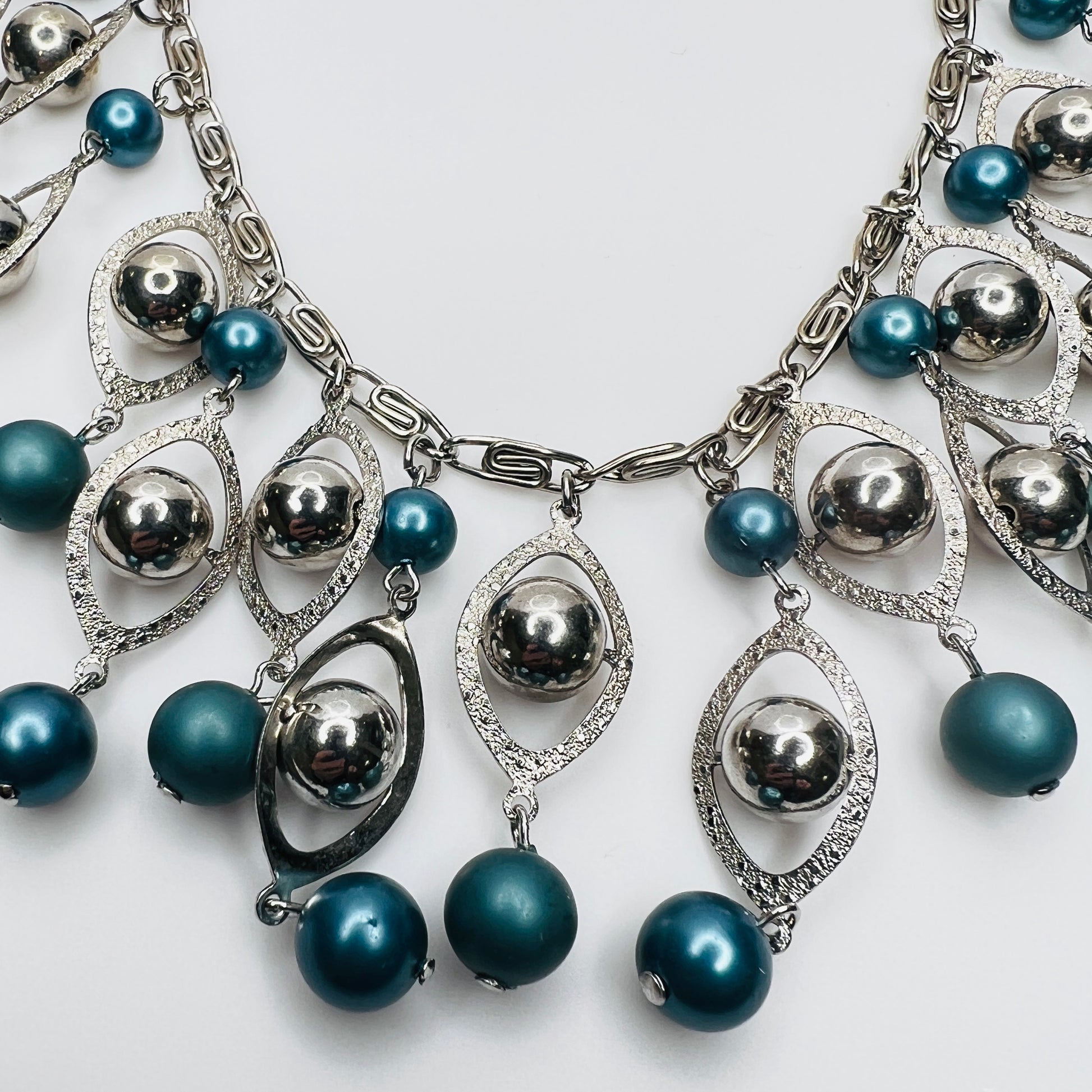 Close-up of silver marquise frames and faux pearl bead detail