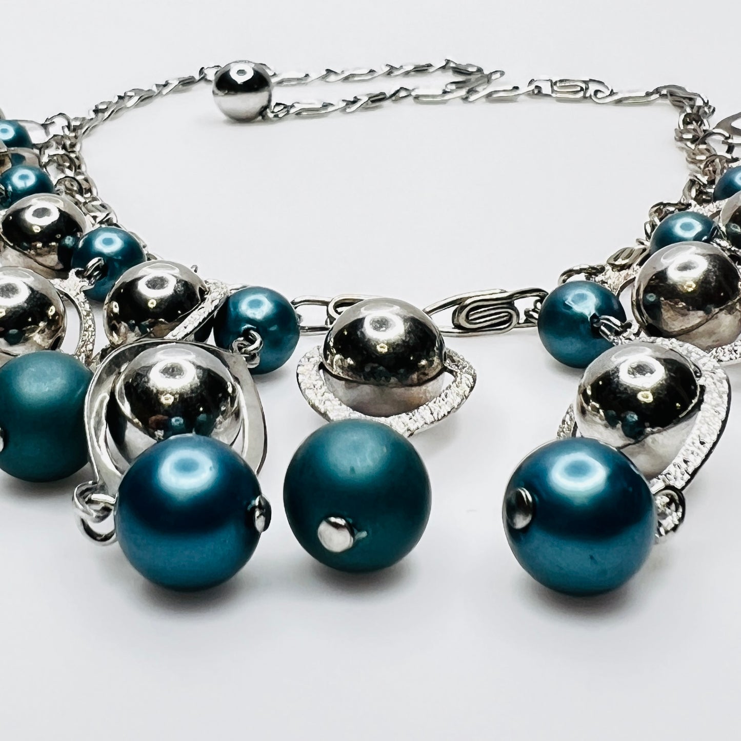 Close-up of silver marquise frames and faux pearl bead detail