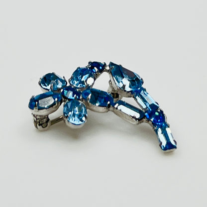 Vintage 1950s blue rhinestone flower brooch in silver-tone setting