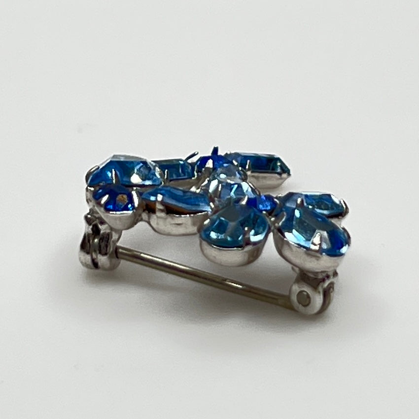 Vintage 1950s blue rhinestone flower brooch in silver-tone setting