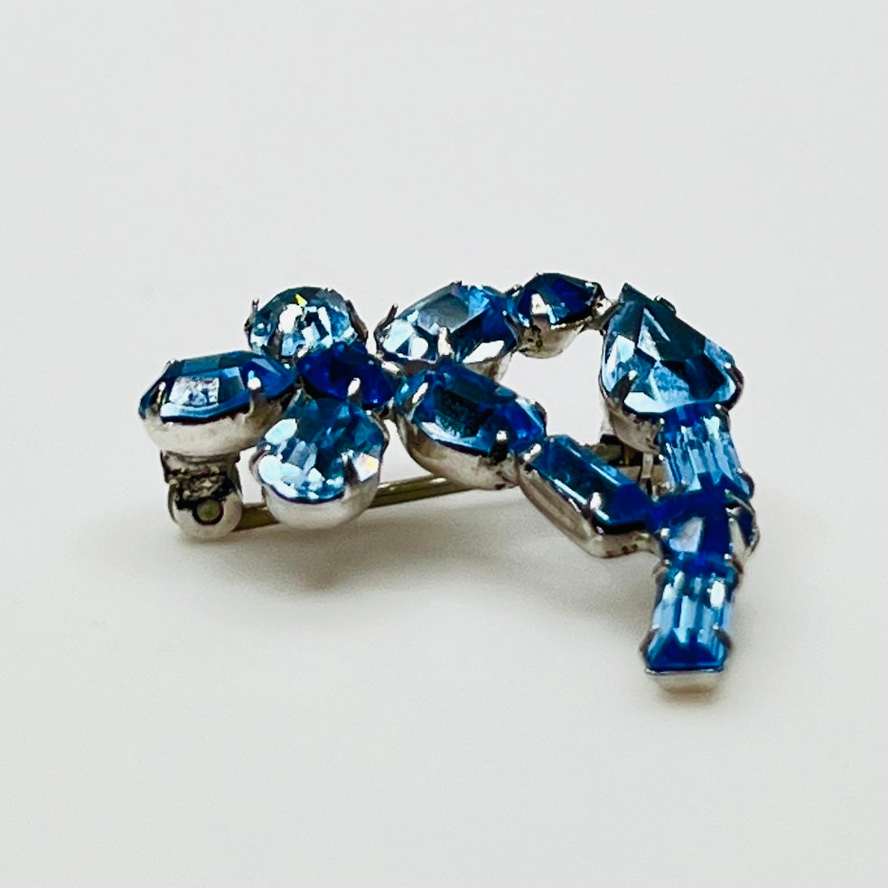 Vintage 1950s blue rhinestone flower brooch in silver-tone setting