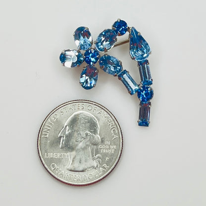 Small sapphire rhinestone brooch shown next to U.S. quarter for scale