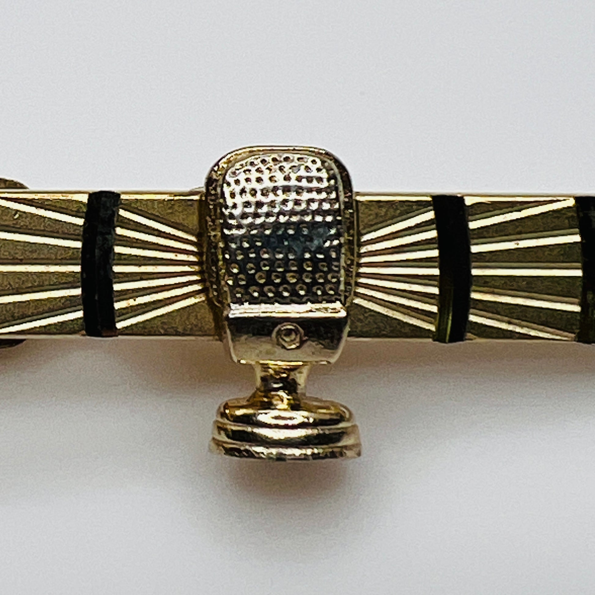 Close-up of microphone detailing and etched gold-tone bar