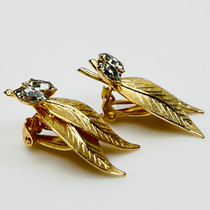 Close-up of gold-tone leaf clip-on earrings with clear rhinestones