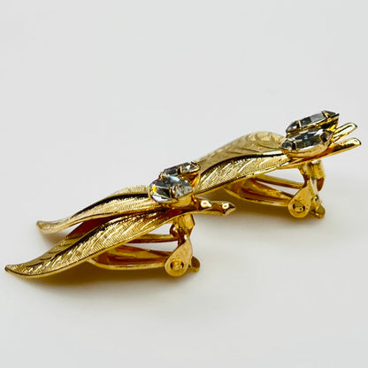 Close-up of gold-tone leaf clip-on earrings with clear rhinestones