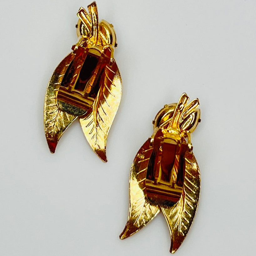 Close-up of gold-tone leaf clip-on earrings with clear rhinestones