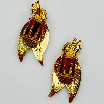 Close-up of gold-tone leaf clip-on earrings with clear rhinestones