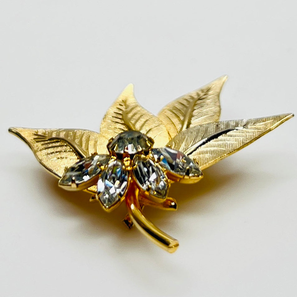 Close-up of gold-tone leaf brooch with clear rhinestones