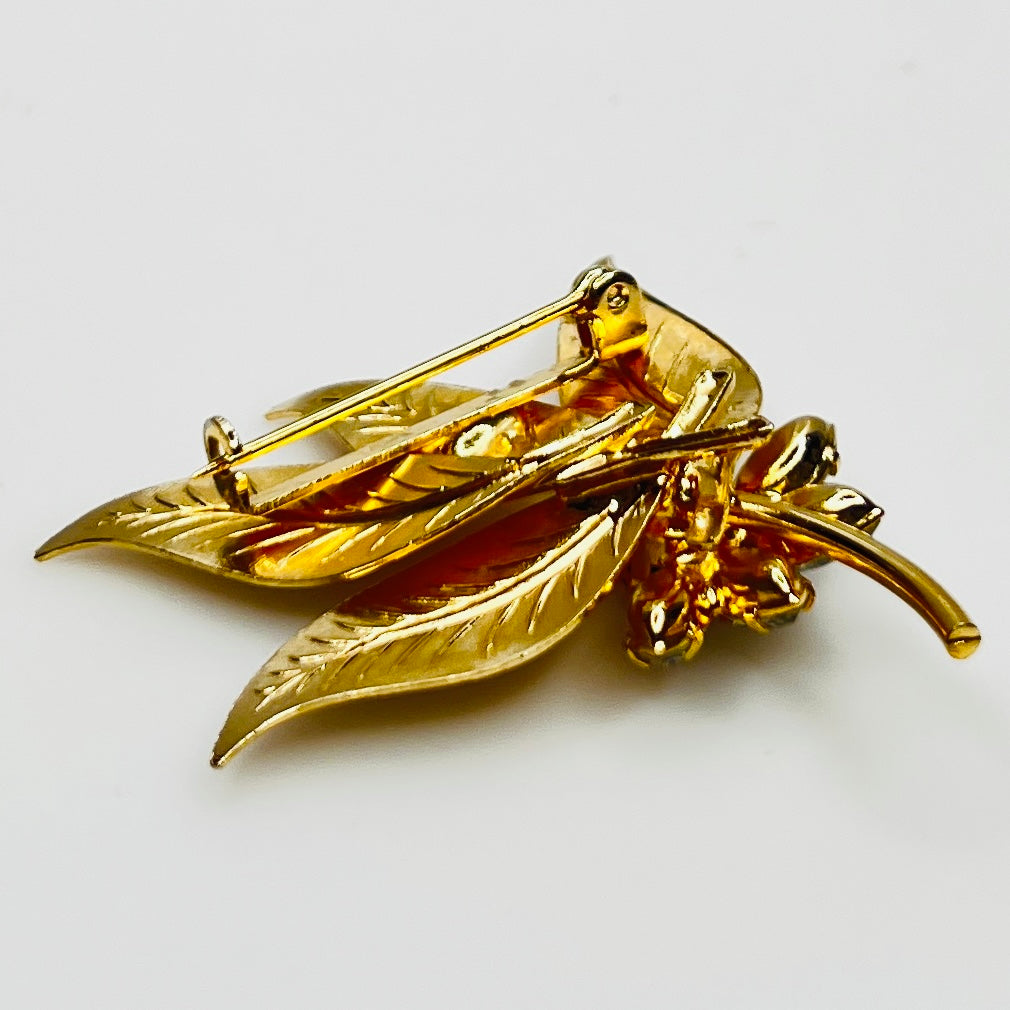 Close-up of gold-tone leaf brooch with clear rhinestones