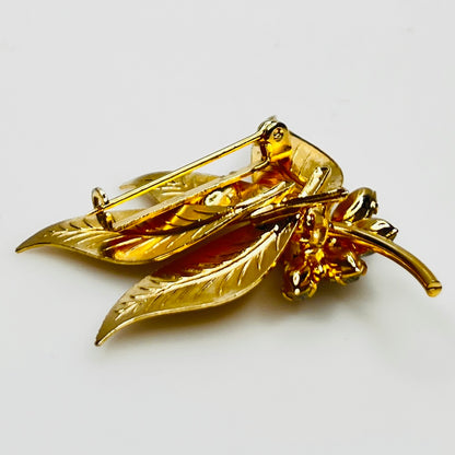 Close-up of gold-tone leaf brooch with clear rhinestones