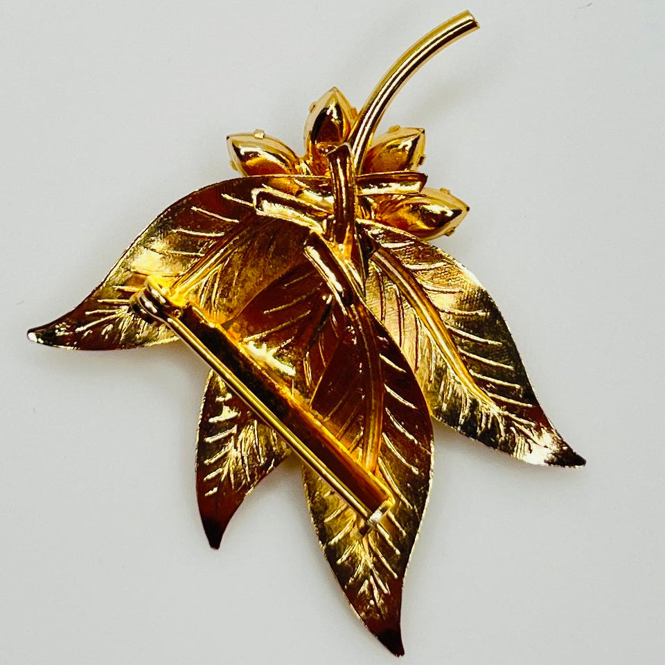 Close-up of gold-tone leaf brooch with clear rhinestones