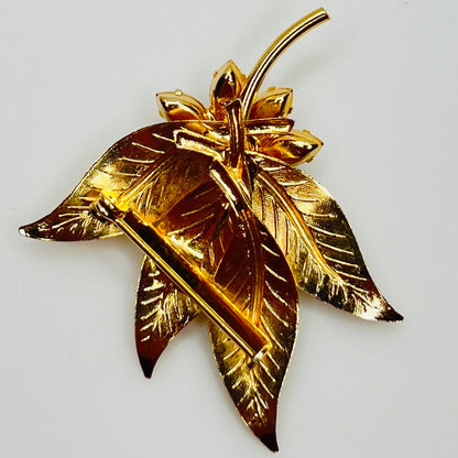 Close-up of gold-tone leaf brooch with clear rhinestones