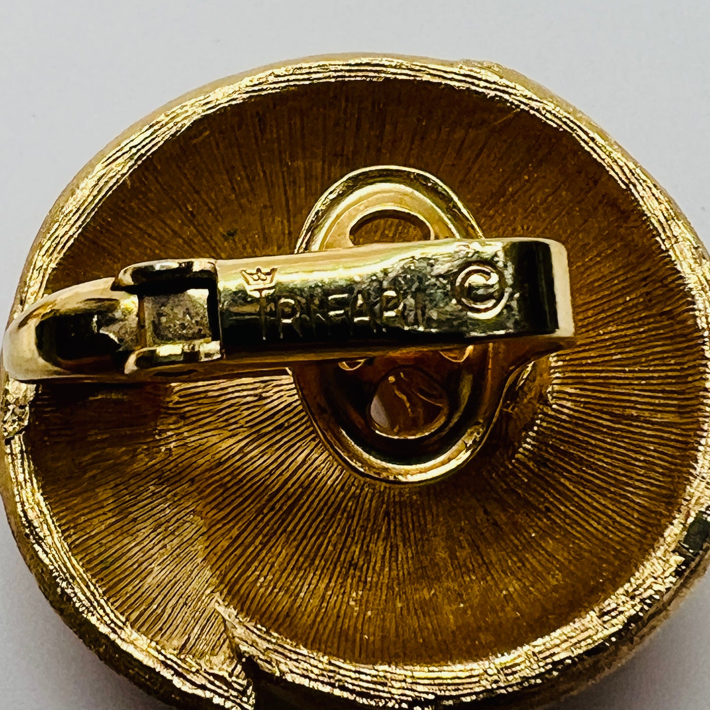 Crown Trifari gold-tone clip-on earrings with swirl design, brushed and polished finish