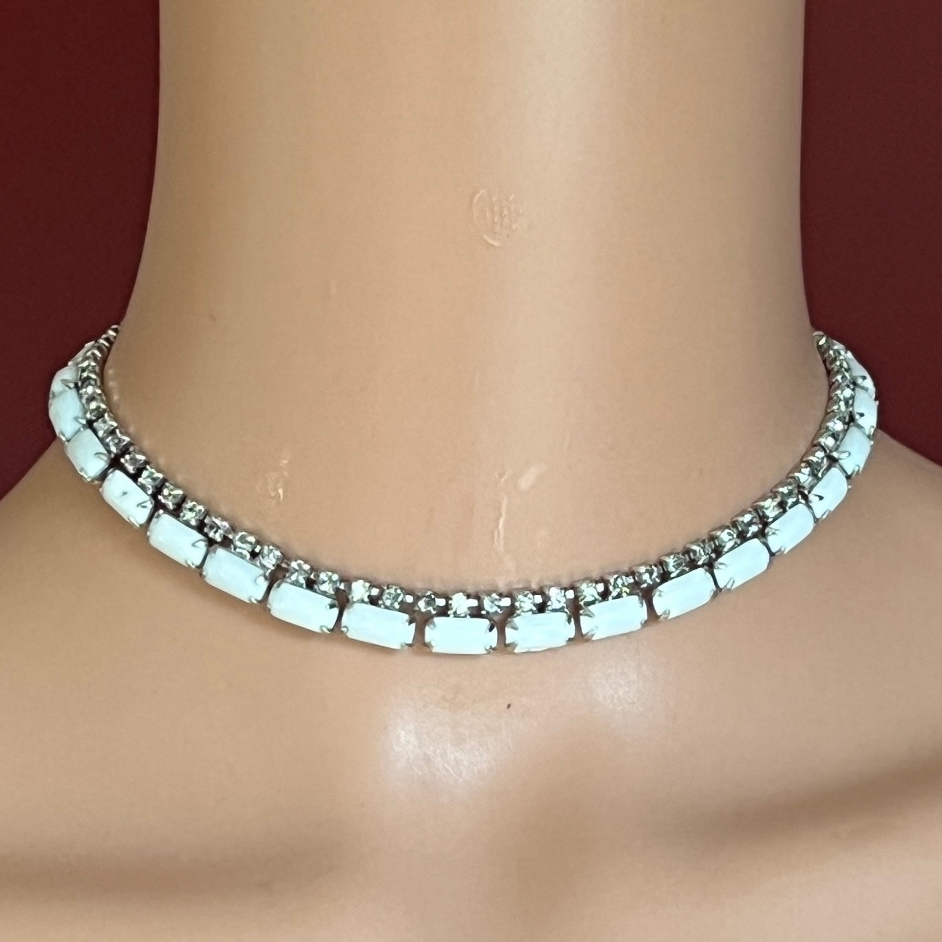 1950s milk glass and rhinestone choker necklace with silver-tone setting and hook closure.