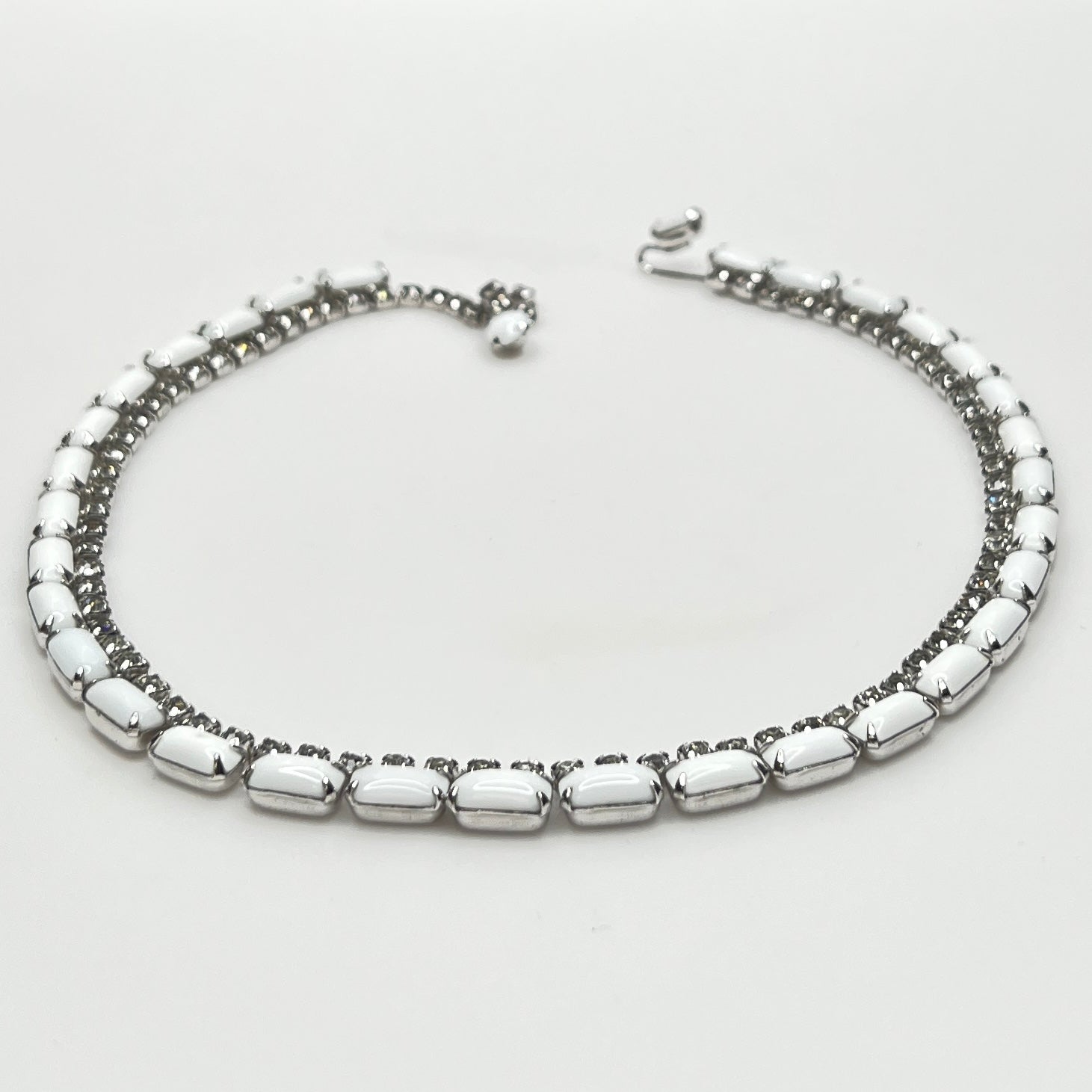 1950s milk glass and rhinestone choker necklace with silver-tone setting and hook closure.