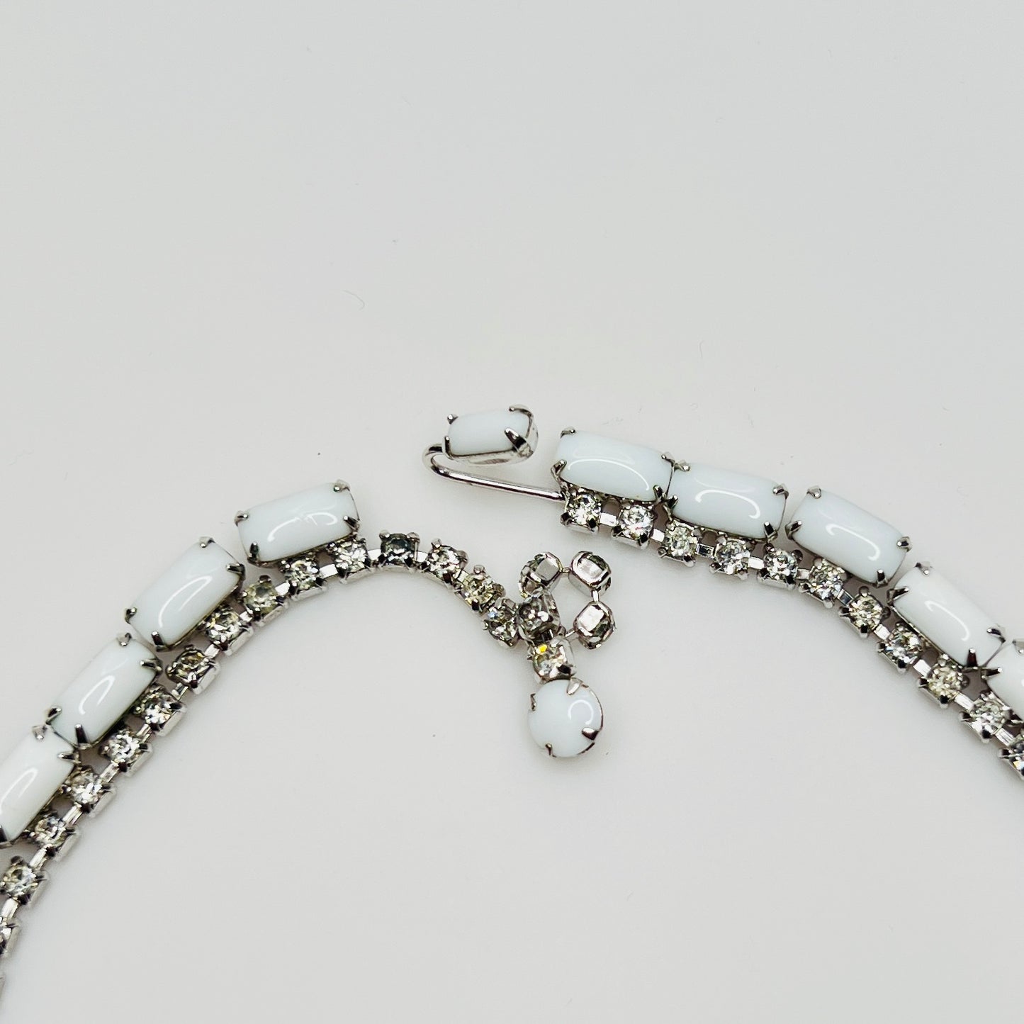 1950s milk glass and rhinestone choker necklace with silver-tone setting and hook closure.