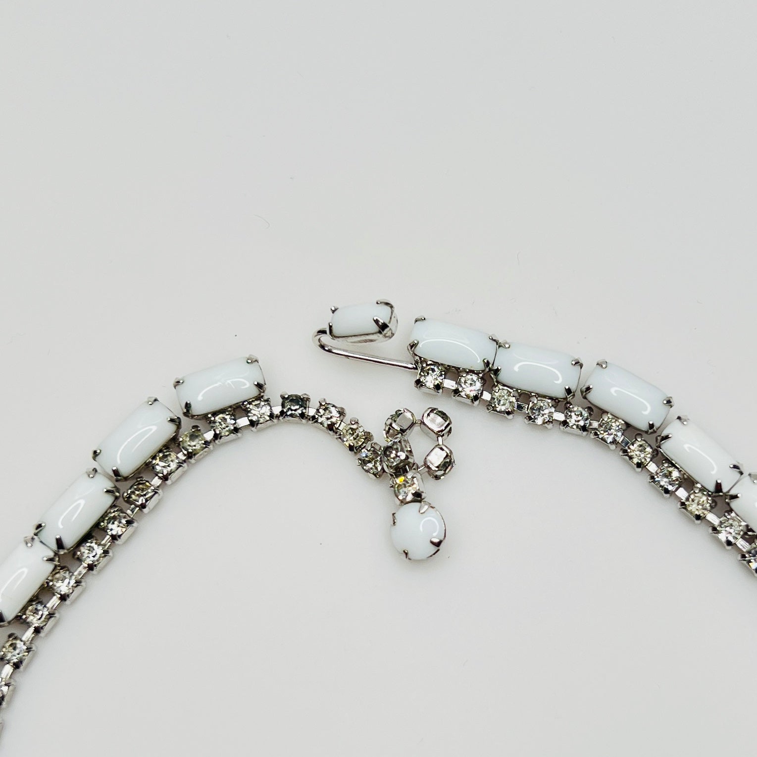 1950s milk glass and rhinestone choker necklace with silver-tone setting and hook closure.