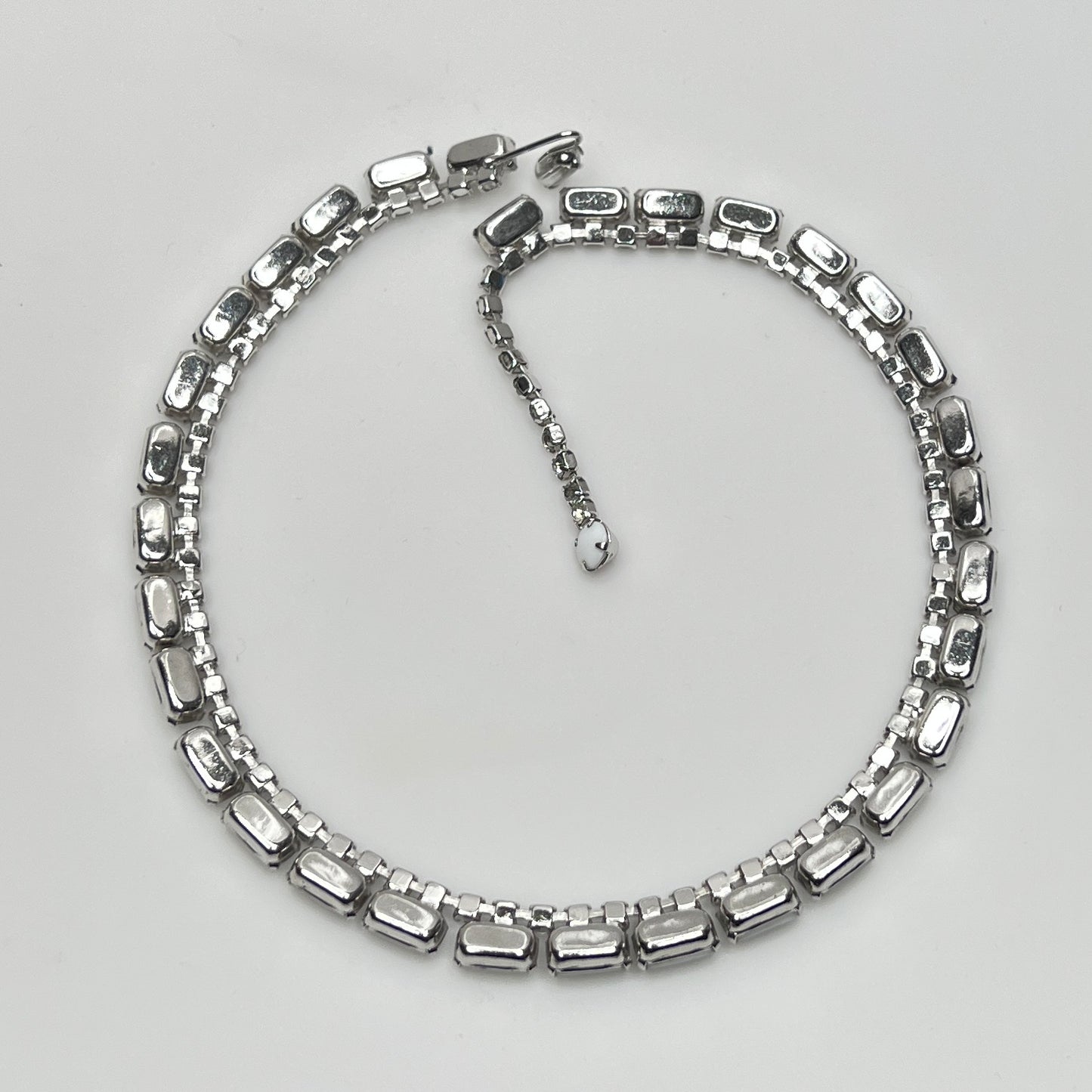 1950s milk glass and rhinestone choker necklace with silver-tone setting and hook closure.