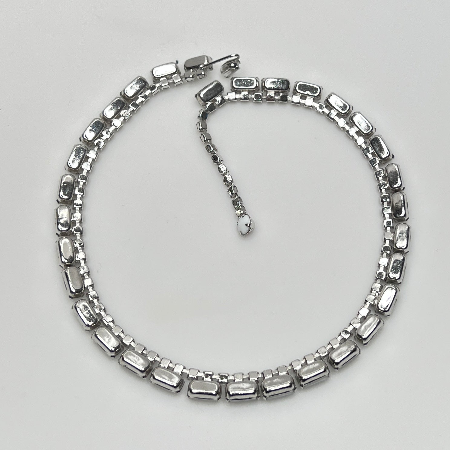 1950s milk glass and rhinestone choker necklace with silver-tone setting and hook closure.