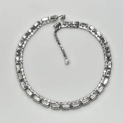 1950s milk glass and rhinestone choker necklace with silver-tone setting and hook closure.