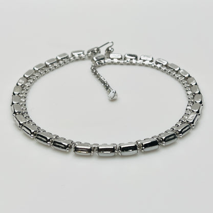 1950s milk glass and rhinestone choker necklace with silver-tone setting and hook closure.