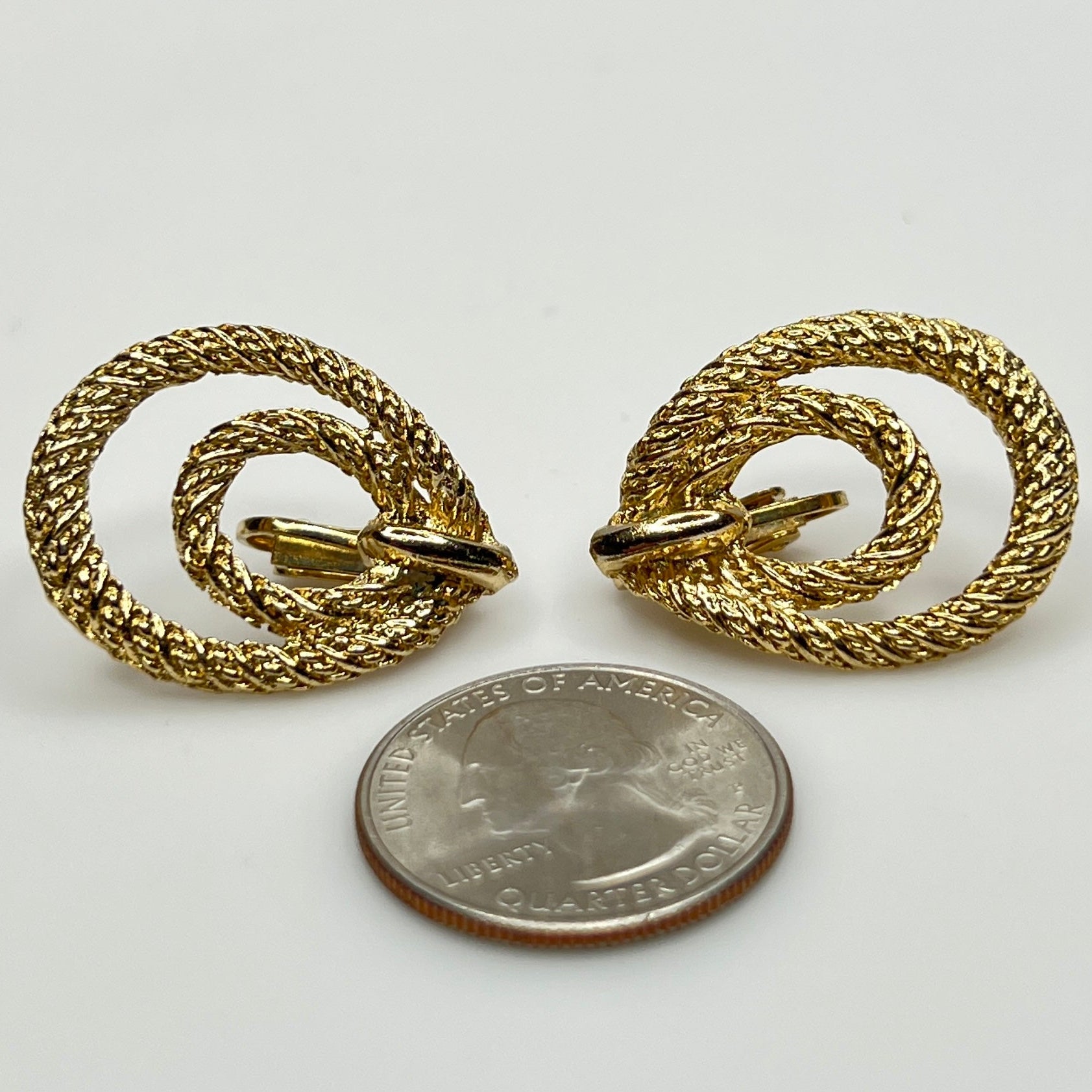 Clip-on earrings with quarter for scale, twisted double-loop design