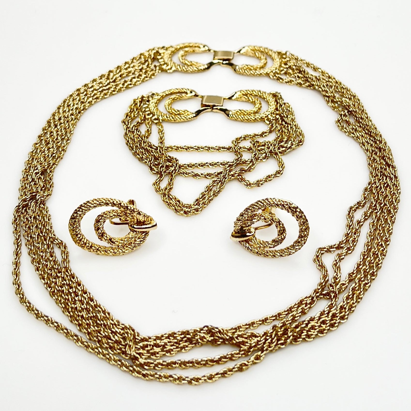 Three-piece vintage gold chain jewelry set with necklace, bracelet, and earrings