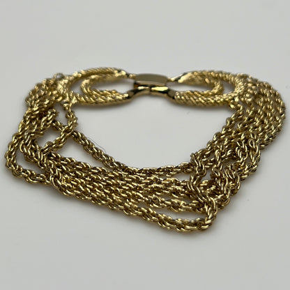 multi-strand gold tone chain bracelet shown on flat surface