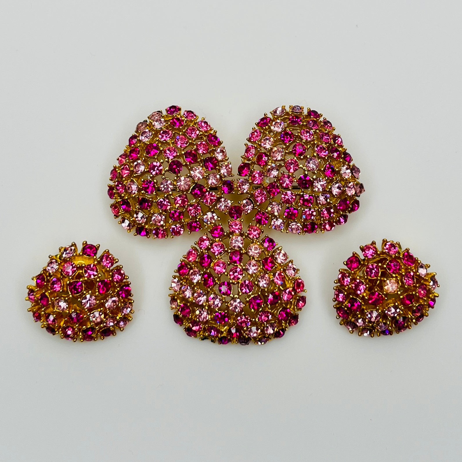 Vintage gold-tone brooch and clip-on earrings with pink rhinestones, mid-century jewelry set