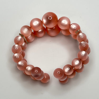 Vintage pink lucite cuff bracelet in open wire design, glowing bead detail