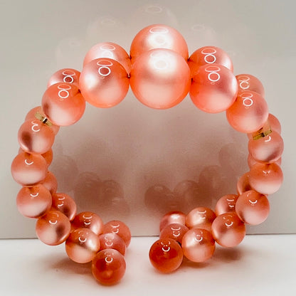 Vintage pink lucite cuff bracelet in open wire design, glowing bead detail